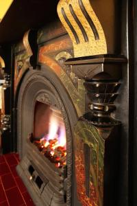 a fireplace with a fire in it at Isabella at Kyneton in Kyneton