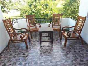 um grupo de cadeiras e uma mesa numa varanda em Lake View Villa em Mirissa