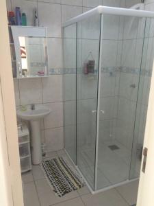 a shower with a glass door in a bathroom at Casa Aconchego e Sossego Imbé in Imbé