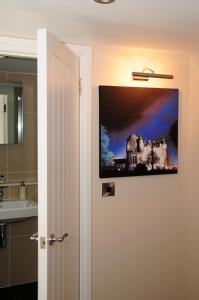 a bathroom with a tv hanging on the wall at Station House - Room Only in Aberfeldy