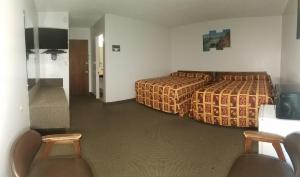 a hotel room with two beds and two chairs at Amber Inn Motel in Bliss