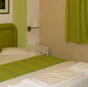 a bedroom with a bed and a green curtain at Perla Apartments in Agia Pelagia