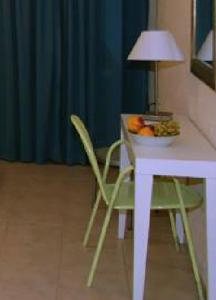 a table and a chair with a bowl of fruit on it at Perla Apartments in Agia Pelagia