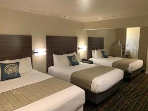 a hotel room with two beds and two lamps at El Castell Motel in Monterey
