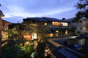 a large building with a swimming pool in front of it at Kyo-machiya Stay WAKA Fushimiinari in Kyoto