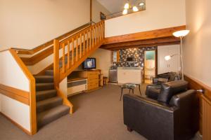 a living room with a staircase and a couch at Balmoral Lodge Motel in Invercargill