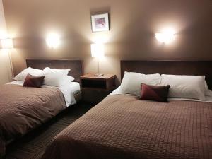 A bed or beds in a room at The Canterbury Inn of Downtown Invermere