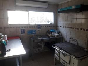 uma pequena cozinha com um lavatório e um fogão em Casa de Campo A Pasos De La Ciudad em Punta Arenas