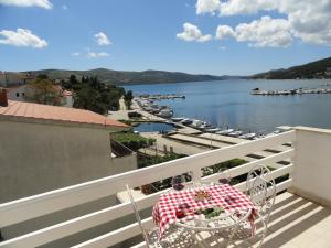 einen Tisch auf einem Balkon mit Blick auf das Wasser in der Unterkunft Villa Samac in Trogir
