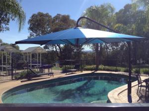 a blue umbrella sitting next to a swimming pool at Commercial Golf Resort in Albury