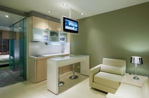 a kitchen with a desk and a chair and a television at Ako Suites Hotel in Barcelona