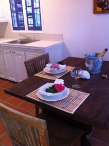 a wooden table with two plates of food on it at Treehouse Cottage in Five Islands Village