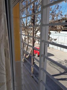 una finestra con vista su un'auto rossa all'esterno di Alojamiento Cba Observatorio a Córdoba