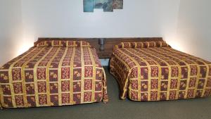 two beds sitting next to each other in a room at Amber Inn Motel in Bliss