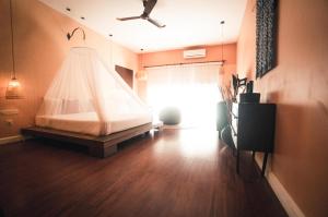 a bedroom with a bed with a mosquito net at iRoHa Garden Hotel & Resort in Phnom Penh