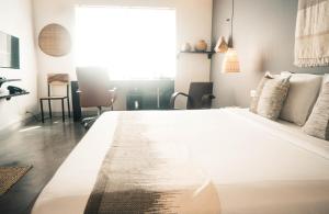 a large white bed in a room with a window at iRoHa Garden Hotel & Resort in Phnom Penh