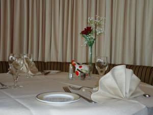 a table with a white table cloth and a vase with flowers at Hotel Le Pole Europeen in Aubange