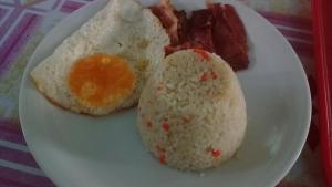 a plate of food with rice and eggs and bacon at Valine Grace Cottages in El Nido