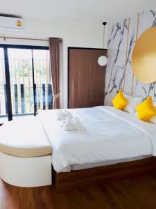 1 dormitorio con 1 cama blanca grande con almohadas amarillas en La La Moon Krabi Poshtel'n' Pool en Krabi