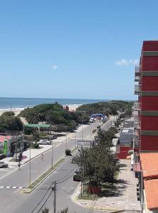 una calle vacía frente a un edificio y el océano en Playadianos en San Clemente del Tuyú