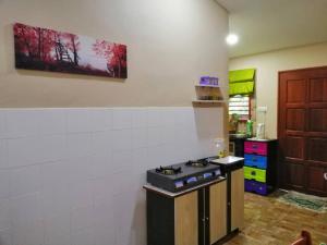 a kitchen with a stove top oven in a room at KhainadzMuslim Homestay in Malacca
