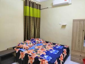 ein Schlafzimmer mit einem Bett mit einer bunten Decke in der Unterkunft KhainadzMuslim Homestay in Malakka