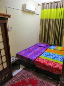 a bedroom with a colorful bed in a room at KhainadzMuslim Homestay in Melaka