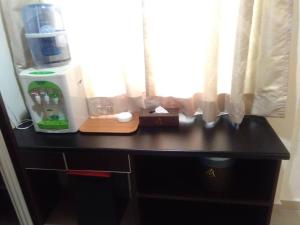 a black dresser with a window and a cutting board at Hotel Mewah Impiana in Kota Bharu