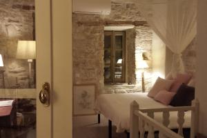 a bedroom with a bed and a stone wall at Village House in Hora-Pythagorio, Samos Island in Chóra