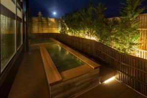 a swimming pool on the side of a house at night at Wat Hotel & Spa Hida Takayama in Takayama