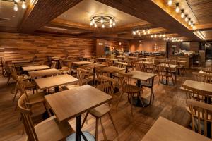 an empty restaurant with wooden tables and chairs at Wat Hotel & Spa Hida Takayama in Takayama
