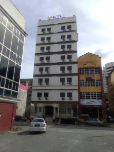 a hotel building with a car parked in front of it at Hotel Mewah Impiana in Kota Bharu
