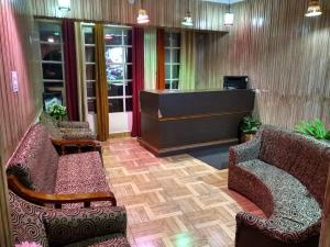 a lobby with two chairs and a reception desk at Hotel Auli D in Joshīmath