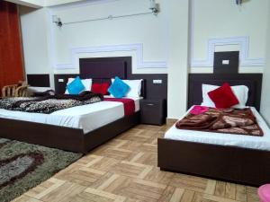 two beds in a room with two at Hotel Auli D in Joshīmath