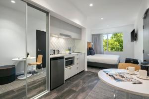Quest Canberra City Walk في كانبرا: شقة صغيرة فيها مطبخ وغرفة نوم