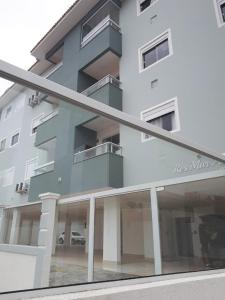 un edificio blanco alto con muchas ventanas en Lindo apartamento, todo novo en Florianópolis