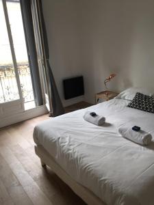 モンペリエにあるCharmant appartement hyper centre Comédieのベッドルーム1室(白いベッド1台、タオル付)