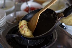 a chicken being fried in a pan on a stove at Sita Beach Resort in Ko Lipe