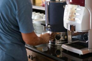 a man is preparing food in a coffee machine at Sita Beach Resort in Ko Lipe