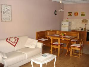 uma sala de estar com um sofá branco e uma mesa em La Casetta dei Cuori em Averara