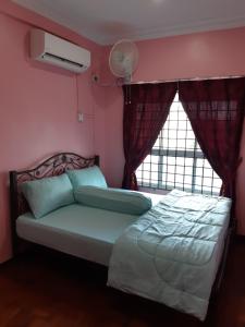 1 dormitorio con cama y ventana en Pantai Puteri Homestay, en Kampong Lereh