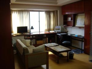 a living room with a couch and a desk with a computer at Special Honmachi in Okayama