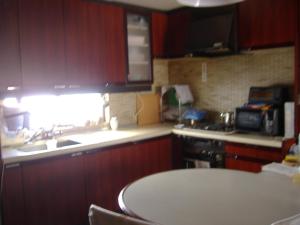 a kitchen with wooden cabinets and a sink and a window at Special Honmachi in Okayama