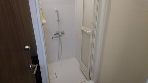 a shower in a bathroom with the door open at Akitaya Annex in Kamakura