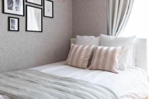 a bed with white sheets and pillows in a bedroom at Exia Daikoku AFP Apartment in Osaka