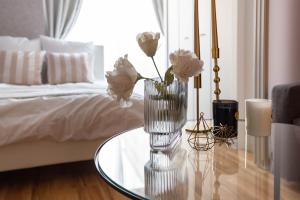 a vase of flowers on a glass table in a bedroom at Exia Daikoku AFP Apartment in Osaka