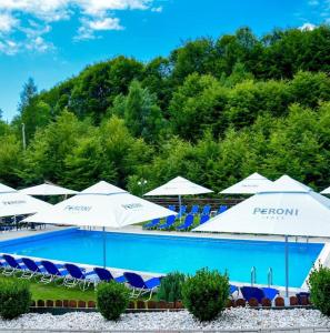 a swimming pool with blue and white umbrellas and chairs at Complex SummerTime in Cavnic