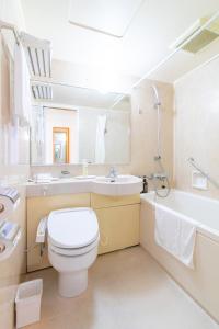 a bathroom with a toilet and a sink and a tub at Bright Park Hotel in Kochi