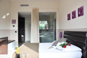 1 Schlafzimmer mit einem weißen Bett und einem Badezimmer in der Unterkunft Rimmel Motel in Parma