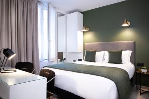 um quarto com uma grande cama branca e uma janela em Hotel Brady - Gare de l'Est em Paris